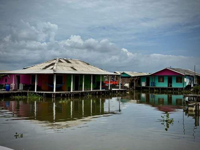 Casas de colores sobre pilotes en la Ciénaga Grande, con su reflejo en el agua